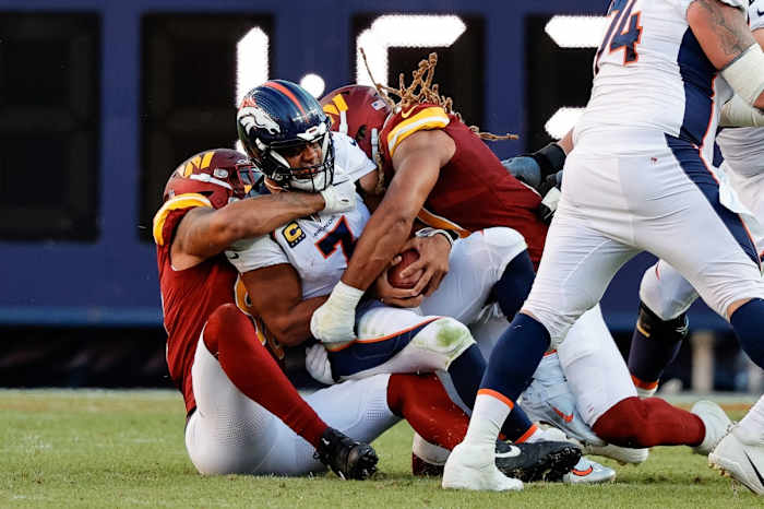 Sep 17, 2023; Denver, Colorado, USA; Denver Broncos quarterback Russell Wilson (3) is sacked by Washington Commanders defensive end Montez Sweat (90) and defensive end Chase Young (99) in the fourth quarter at Empower Field at Mile High.